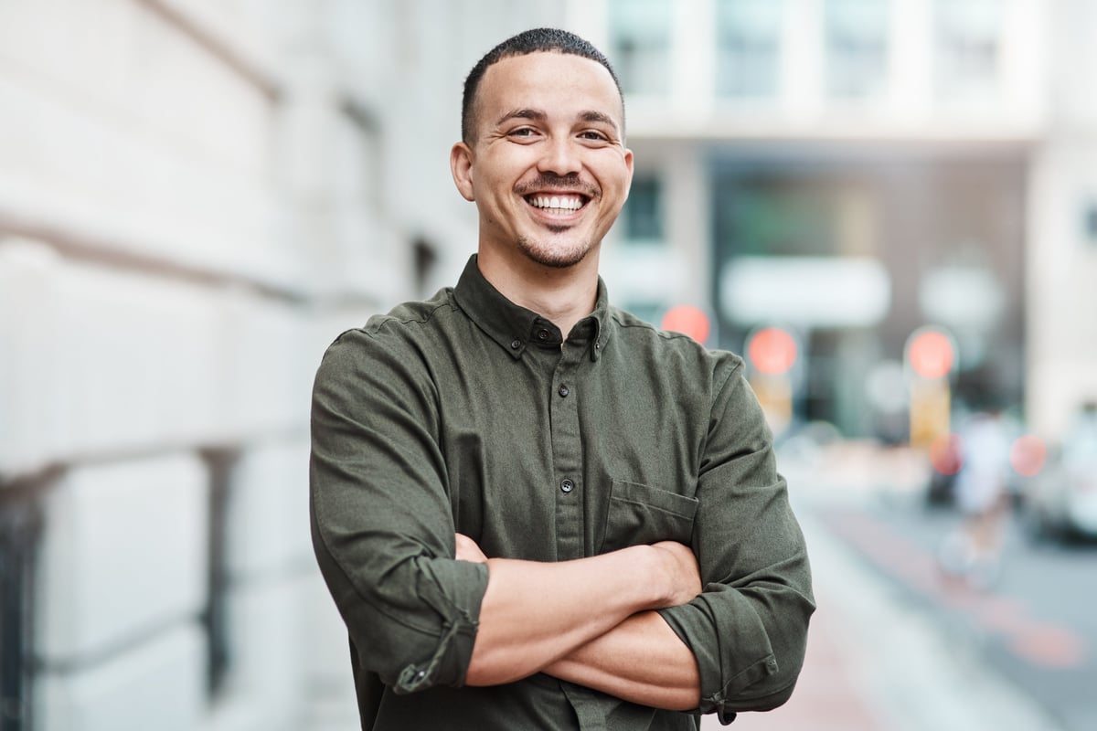 Portrait of a confident young businessman standing against an urban background
